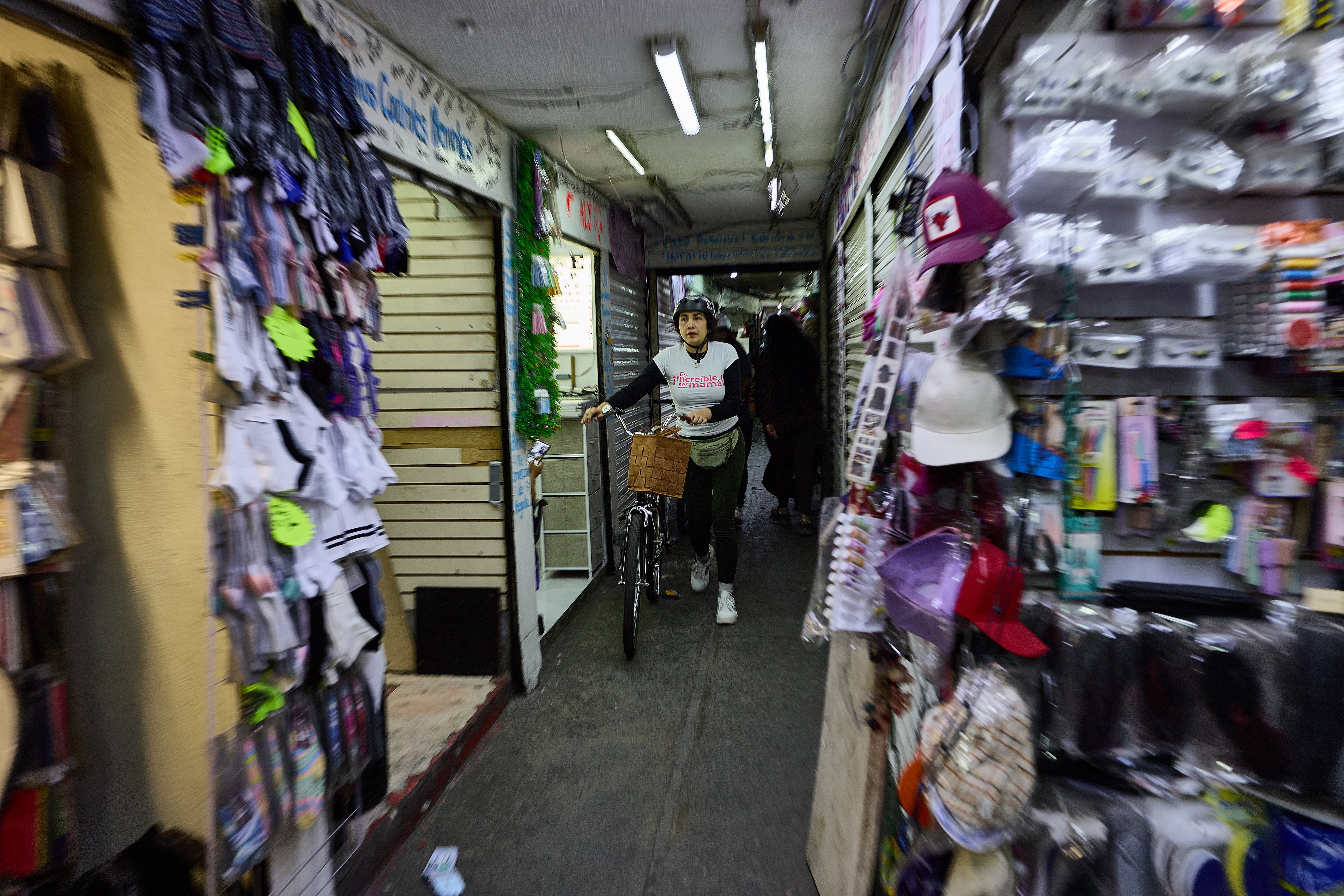 Una peatón con su bicicleta en el pasillo del comercio en los pasos a desnivel de Coruña.