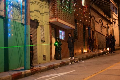 Jóvenes apuntan con un láser a sus contrincantes en la otra esquina de la calle.