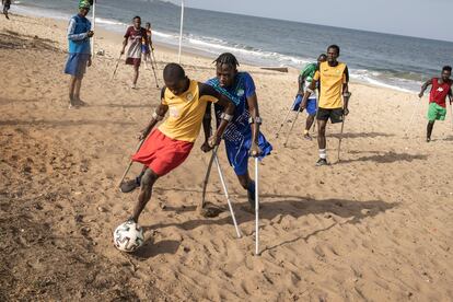 Los miembros de un equipo de fútbol de la Asociación Deportiva de Amputados de una Pierna juegan durante una sesión de entrenamiento en Freetown, Sierra Leona, el 16 de abril de 2022. Este equipo fue creado en 2002, al final de la guerra, por Mamoudi Samai, pastor de una iglesia de la región. Participan un total de 70 jugadores, entre ellos una docena de mujeres, a los que les falta un brazo o una pierna.