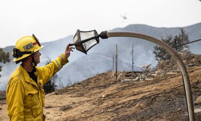 Un bombero toca una farola calcinada por las llamas de un incendio forestal en El Dorado, California (EE UU).