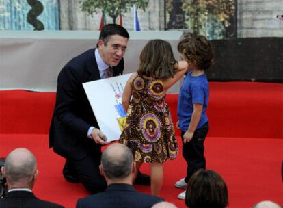 Dos niños entregan al 'lehendakari' López un dibujo de una tarta durante los actos de celebración del 30 aniversario del Estatuto de Gernika.
