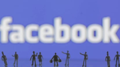 Figuras creadas con una impresora 3D ante el logo de Facebook.