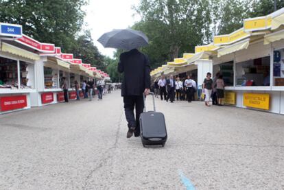 La lluvia de ayer dejó este panorama semidesierto en la Feria del Libro de Madrid, en el Paseo de Coches del Retiro.