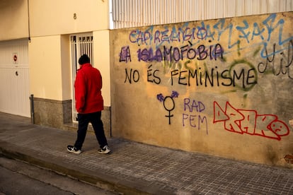 Un hombre pasa por delante de una pintada contra la islamofobia en una calle de Calella, en enero de 2024.