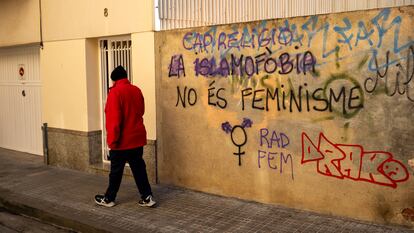 Un hombre pasa por delante de una pintada contra la islamofobia en una calle de Calella, en enero de 2024.