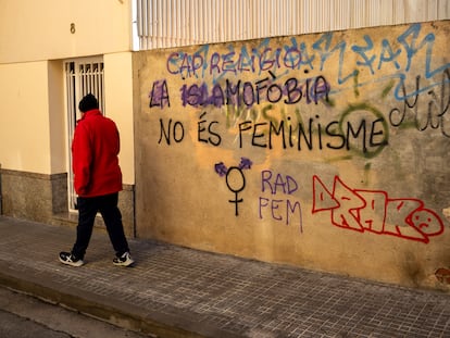 Un hombre pasa por delante de una pintada contra la islamofobia en una calle de Calella, en enero de 2024.