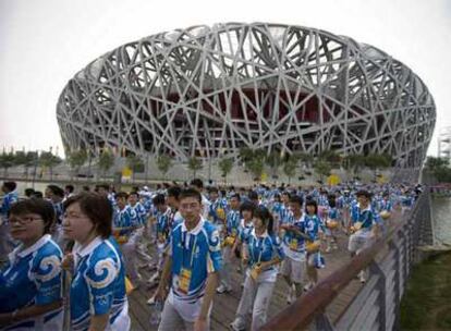 Un grupo de voluntarios de los Juegos Olímpicos, durante un ensayo frente al Estadio Nacional de Pekín