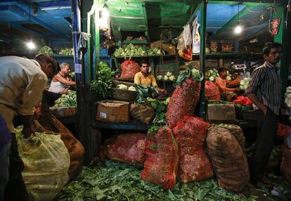 Vendedores en su puesto de un mercado mayorista de frutas y verduras en Bombay, India.