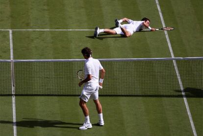 Federer observa a Kukushkin, en el suelo, nada más hacerle un tanto.