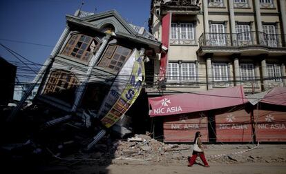 Una mujer pasea frente a un edificio destrozado Katmandú tras el seísmo que desvastó Nepal el pasado 25 de abril.