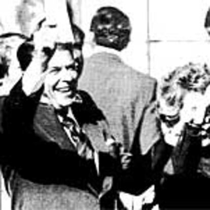 Ronald Reagan y su esposa, Nancy, saludan a sus partidarios, con gesto de triunfo, poco antes de depositar su voto