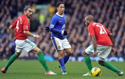 Chico Flores, a la izquierda, presiona a Pienaar, del Everton, junto a su compañero Tiendali.