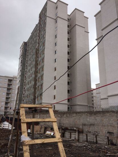 Um grande muro separa o terreno da construção dos prédios.