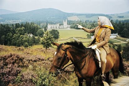 La reina Isabel II a caballo mirando hacia el Castillo de Balmoral, Escocia, a lo lejos, durante las vacaciones de verano anuales de la Familia Real, en septiembre de 1971. 