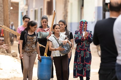 Imagen de la grabación del documental 'Al borde de los sueños' en una calle de El Barsha mientras las integrantes del grupo de teatro anuncian su obra.