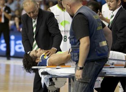 Las asistencias sacan en camilla a Printezis, del Unicaja, tras romperse un hombro en una caída.