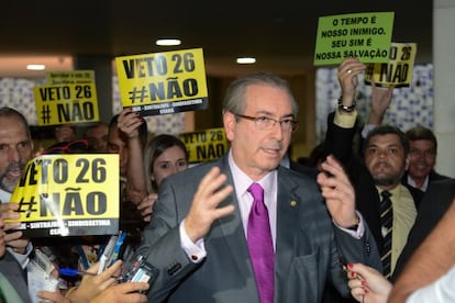 Cunha e cartazes pedindo a derrubada do veto