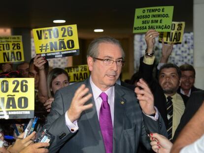 Cunha e cartazes pedindo a derrubada do veto
