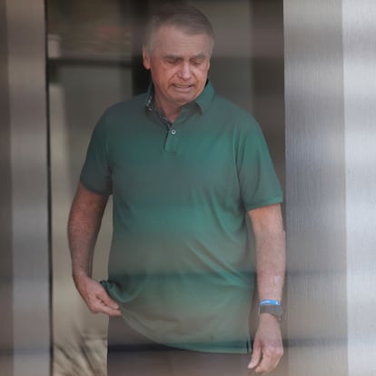 Brazil's former President Jair Bolsonaro stands at the entrance of his home where he is under house arrest in Brasilia, Brazil, Thursday, Sept. 11, 2025. (AP Photo/Luis Nova)