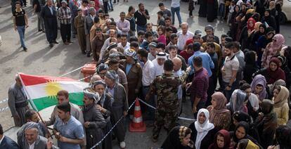 Un grupo de personas espera la apertura de un centro electoral, en Erbil