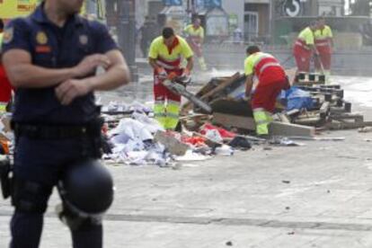 Los servicios de limpieza municipales retiran los restos del punto de información el 15-M en la Puerta del Sol.
