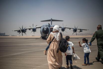 Una mujer y tres niños se encaminan a abordar el avión medicalizado del Ministerio de Defensa en un aeropuerto de El Cairo, Egipto.