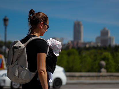 Una mujer pasea con su bebé, en una foto de archivo tomada en Madrid.