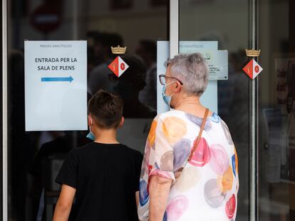 Una mujer acompaña este lunes a un menor a hacerse una prueba analítica para conocer sus niveles de plomo en sangre en Bonmati (Girona).