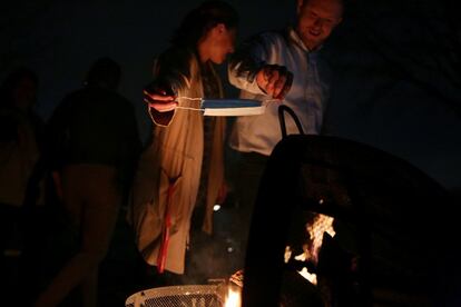 Dos personas tiran un cubrebocas al fuego durante, en Dallas, el miércoles pasado.