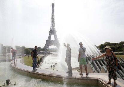 La gente se refresca en las fuentes de los jardines de Trocadero, con la Torre Eiffel de fondo.