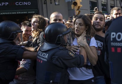 A Mossos police officer holds back a protester.