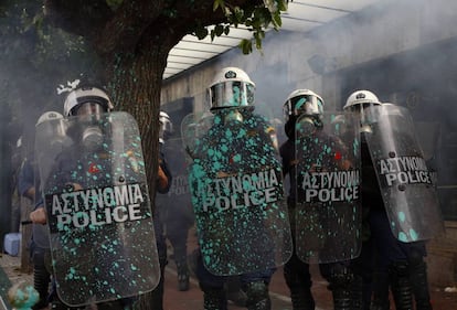 Policías antidisturbios, con los escudos manchados de pintura lanzada por los manifestantes.