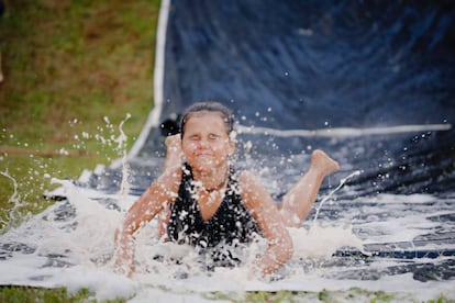 Una niña baja por un tobogán de agua. 