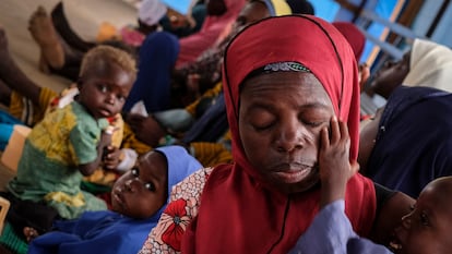 Una madre agotada con su hijo en el centro de educación nutricional para casos moderados de Aguié. Al fondo, el cabello de otro niño se ha aclarado, un síntoma habitual de la malnutrición.