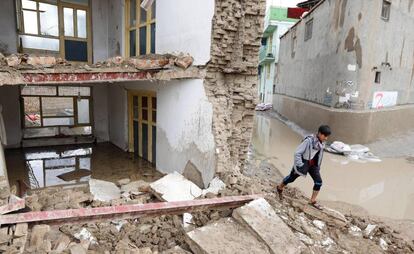 Un niño pasa junto a los escombros de una casa, este martes, tras las inundaciones registradas el oeste de la ciudad de Kabul (Afganistán). Al menos 25 personas han muerto y un centenar de edificios se han derrumbado en todo el país por las inundaciones, según medios locales.