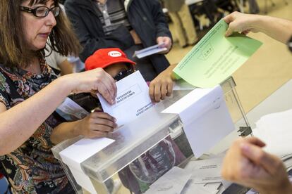 Una ciutadana vota acompanyada d'un nen al centre cívic La Sedeta.