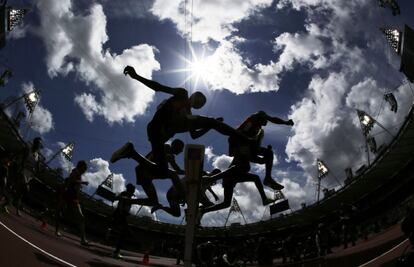 Las siluetas de unos atletas durante la prueba de 3.000 metros obstáculos.