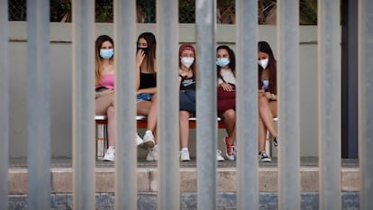 Jóvenes con mascarillas esperan el tren en Canet de Mar (Barcelona), en el verano de 2021.