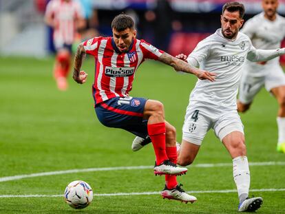 Correa trata de zafarse de Pulido durante el Atlético-Huesca (2-0) disputado este jueves en el Wanda Metropolitano. (AP Photo/Manu Fernandez)