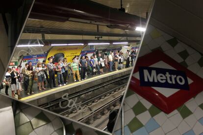 Un grupo de viajeros espera la llegada del metro.