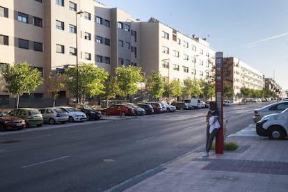 Una adolescente espera el autobús en el barrio de Buenavista, donde han ido a vivir los hijos de los pioneros del sector 3, en Getafe.