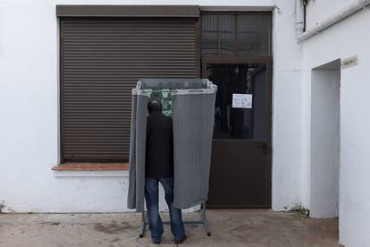 Un hombre elige una papeleta electoral en un instituto de Sevilla.