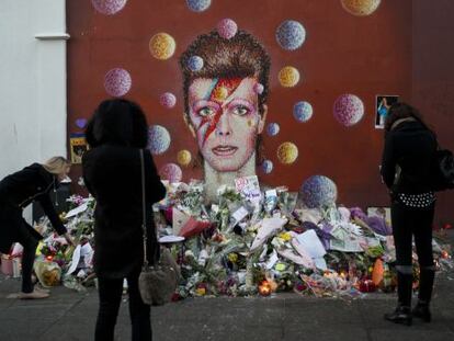 Altar espont&aacute;neo junto a un mural dedicado a Bowie en Londres.