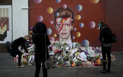 Altar espont&aacute;neo junto a un mural dedicado a Bowie en Londres.