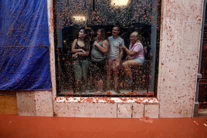 Varios vecinos observan la batalla desde el interior de un edificio.