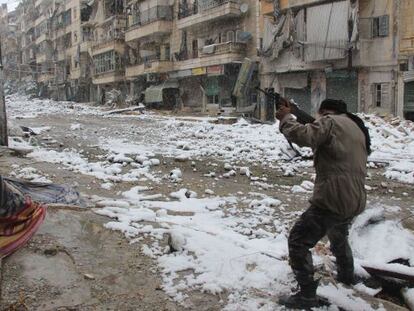 Un combatiente rebelde dispara en una calle nevada de Alepo, Siria.