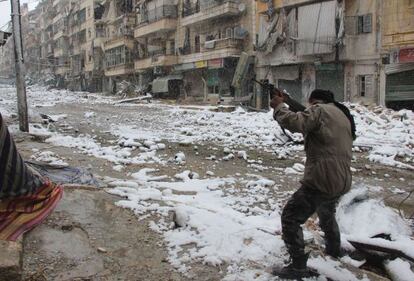 Un combatiente rebelde dispara en una calle nevada de Alepo, Siria.