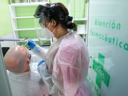 Una trabajadora sanitaria realiza un test de antígenos a un hombre en una farmacia de Madrid.