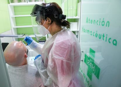 Una trabajadora sanitaria realiza un test de antígenos a un hombre en una farmacia de Madrid.