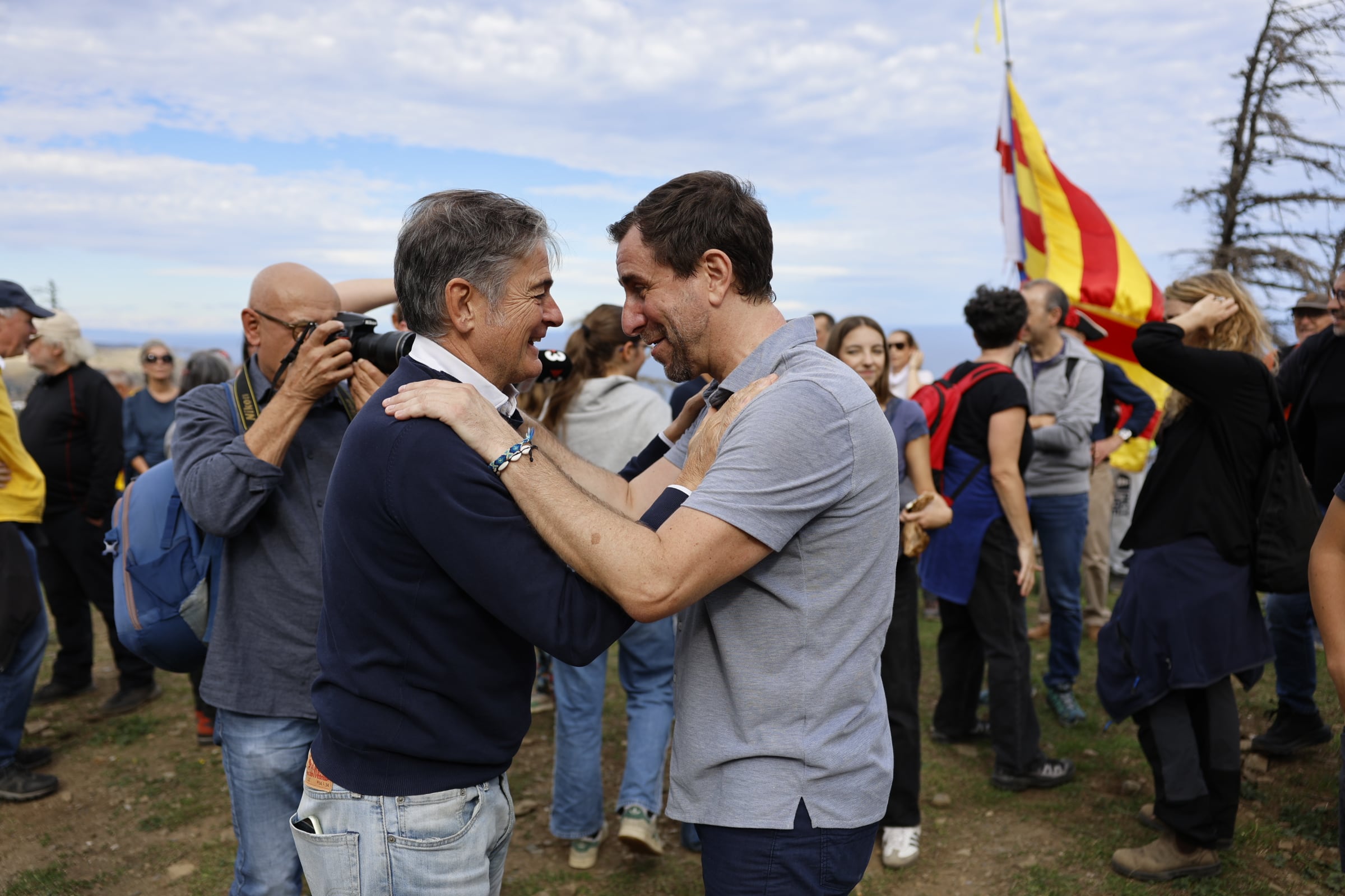 Toni Comín saluda a Oriol Pujol, hijo pequeño de Jordi Pujol, en su retorno simbólico a Cataluña tras ocho años en Bélgica.